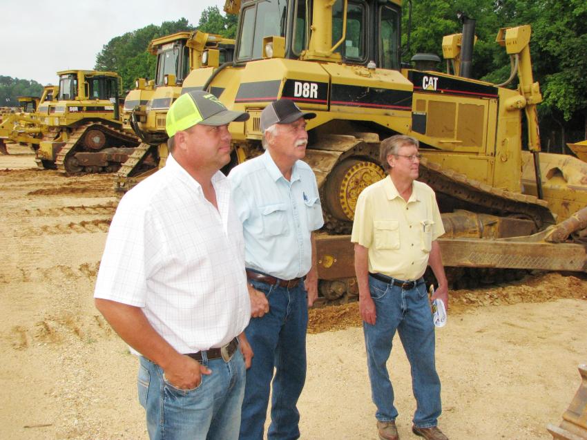 Admiring the lineup of Cat D8R’s about to be auctioned off (L-R) are Quint Crager and Mike Crager of Quinco Contracting, Chatom, Ala.; and Frank Corley, Corley Inc., Chapman, Ala.