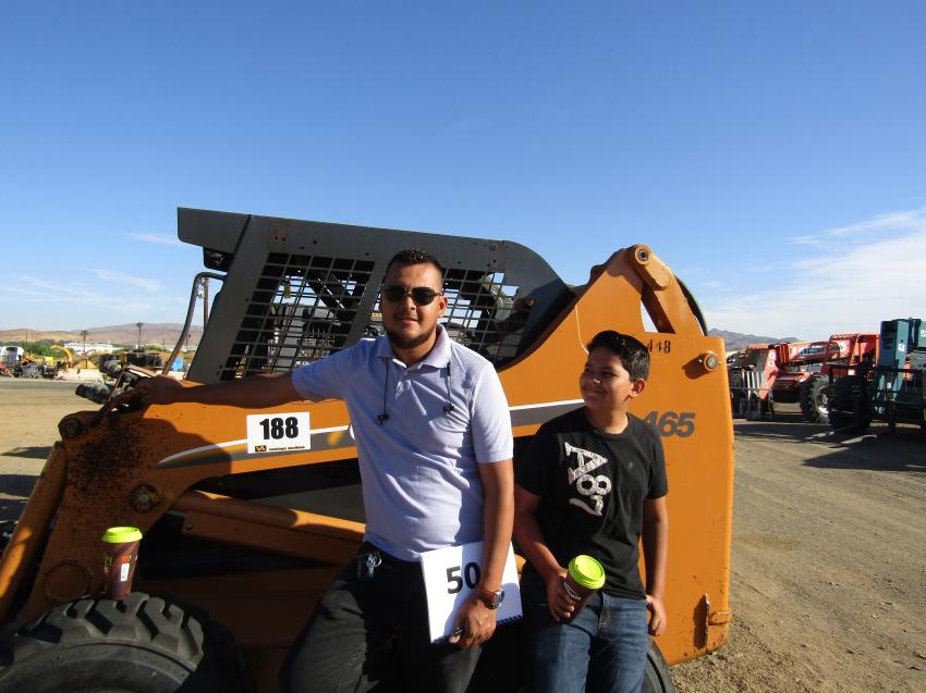 Edgar Rius Sr. (L) and Edgar Rius Jr. of Hemet, Calif., search for land clearing equipment. They examine this 2005 Case skid steer.
