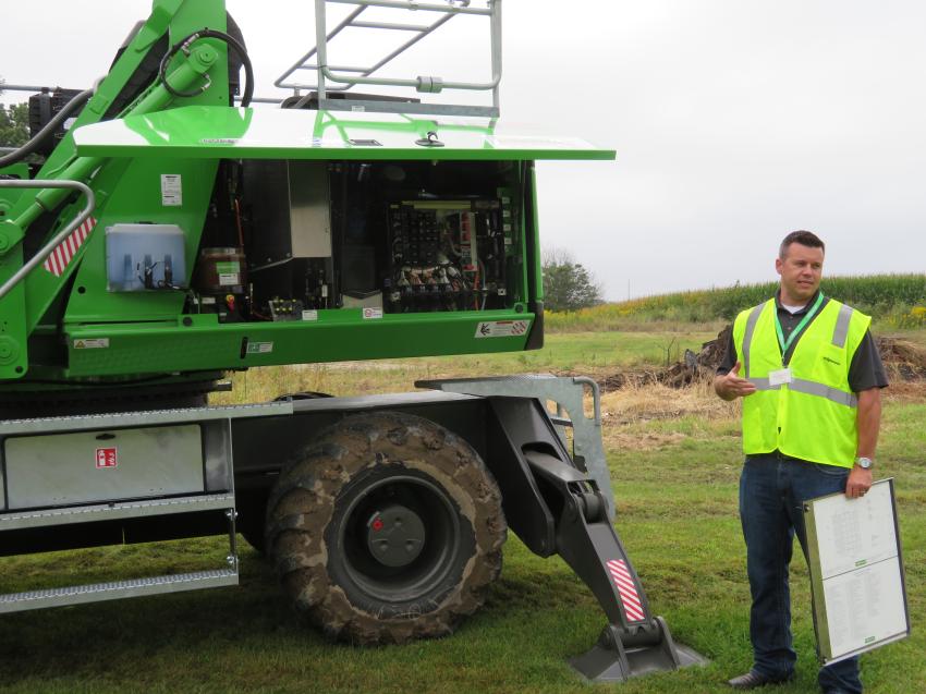 Darren Sudduth, manager of the tree care industry of Sennebogen, points out the engine features of the Sennebogen 718E.
