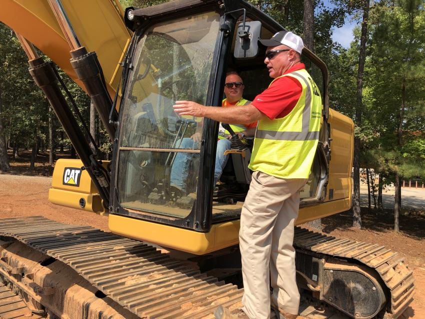 Eric Curtis with WM. R. Curtis Company gets an introduction to the Cat 320 excavator from Brian Jackson of Gregory Poole Equipment Company.