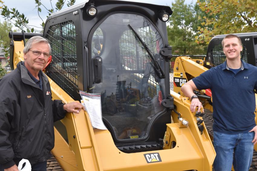 Nick Nicholson (L), president of Comprehensive Construction in Baltimore,  Md., and his son Tyler were looking at a Cat CTL. Their company handles a lot of snow work, so they really value the machine’s treads.