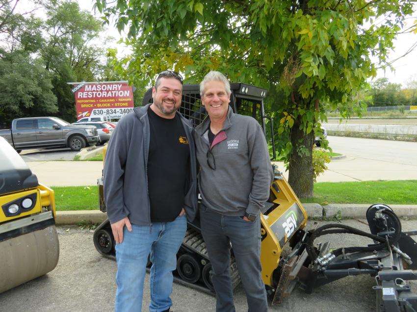 Rich Swan (L) shows this ASV RT-30 tracked skid steer equipped with a Harley rake to Thomas Papais, owner of Rose Landscape Design.

