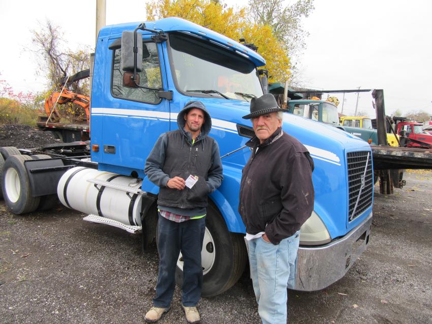 Tony Perz (L) and Mike Ruffo of HE Concrete Supply consider a bid on this tractor.