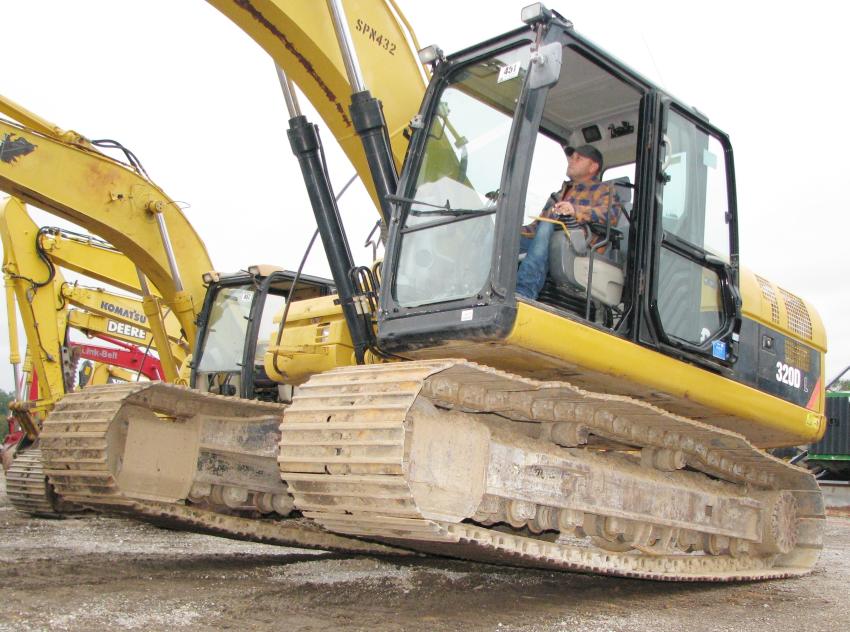 Putting a little air under the tracks while test-operating a Cat 320DL excavator is Jamie Drennen of Breakwater Marine, Biloxi, Miss.
