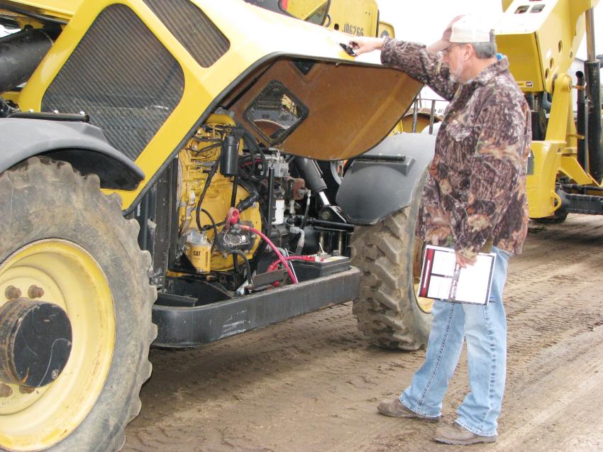 As the Cat telehandlers are lined up and about to go across the ramp to be auctioned, Sean Sumrall of Larry Sumrall Contractors, Laurel, Miss., takes one last look at the ones he’s interested in. 
