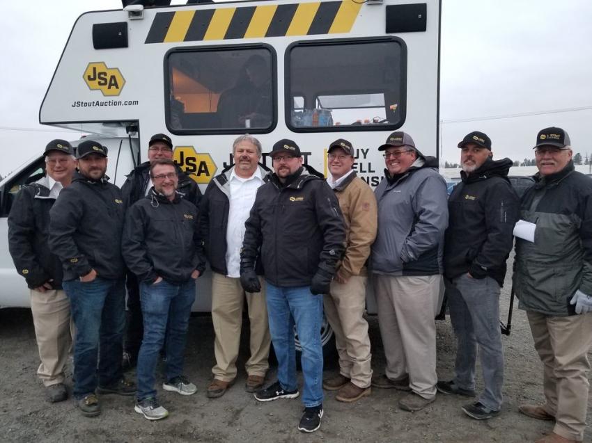 Jake Stout, (C), fellow employees and the auctioneer team, mark what is expected to be one of the company’s most successful auctions, with a picture. 
