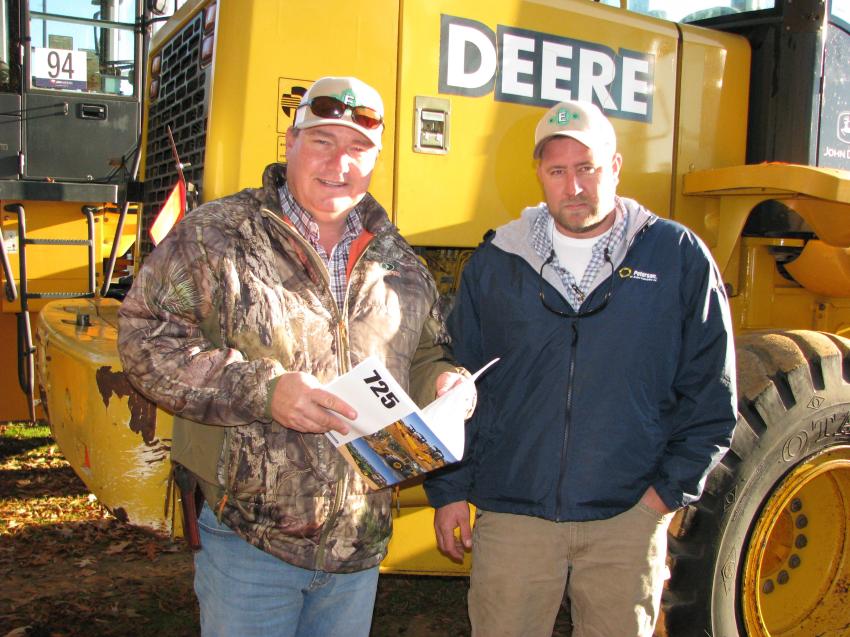 Cam Lanier (L) and Mitch Cannon of Evergreen Construction, Opelika, Ala., were interested in some of the wheel loaders in the sale lineup, including this John Deere 624H they were reading up on.