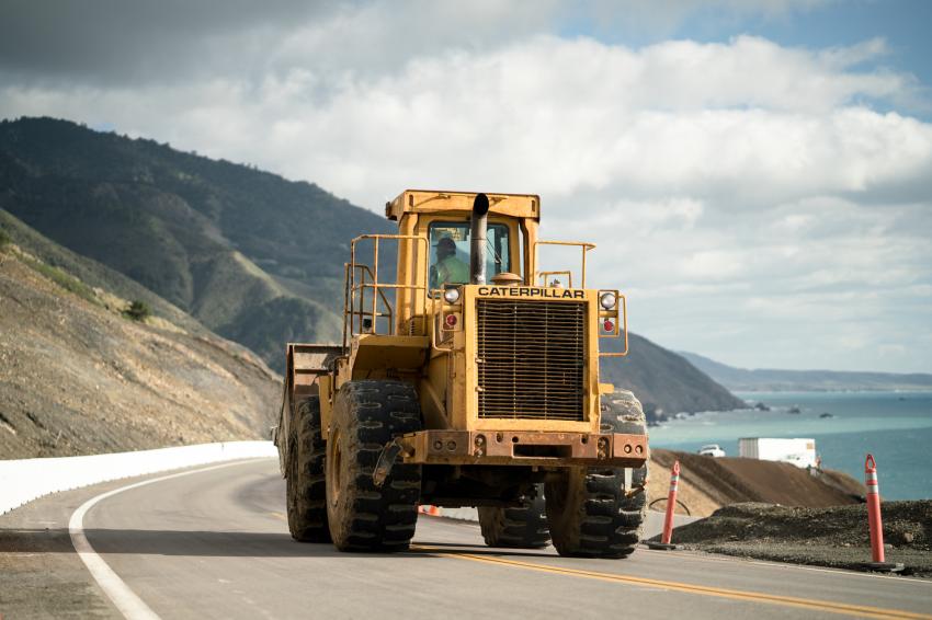 A Caltrans loader cruises Highway 1 in Big Sur after cleaning up material washed onto the highway following winter storms.
