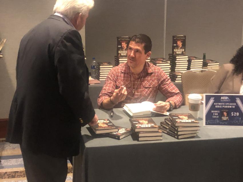 Kris “Tanto” Paronto, keynote speaker at the AED Summit in Chicago, signs his book, “The Ranger Way,” for an attendee. Paronto spoke about the 13-hour ordeal of the terrorist attack on the U.S. special mission in Benghazi, Libya.