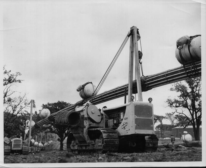 Pipeline construction often required a host of pipelayers to place long sections of pipe. Eight Cat pipelayers are visible in this Sept. 11, 1954 scene as they hold a 600-ft. section of pipe. They will walk it to the edge of the Niagara River during construction of the first pipeline, a natural gas line for the Tennessee Gas Transmission Company, to cross the river.
(Dunbar & Sullivan Dredging Company collection, HCEA Archives)