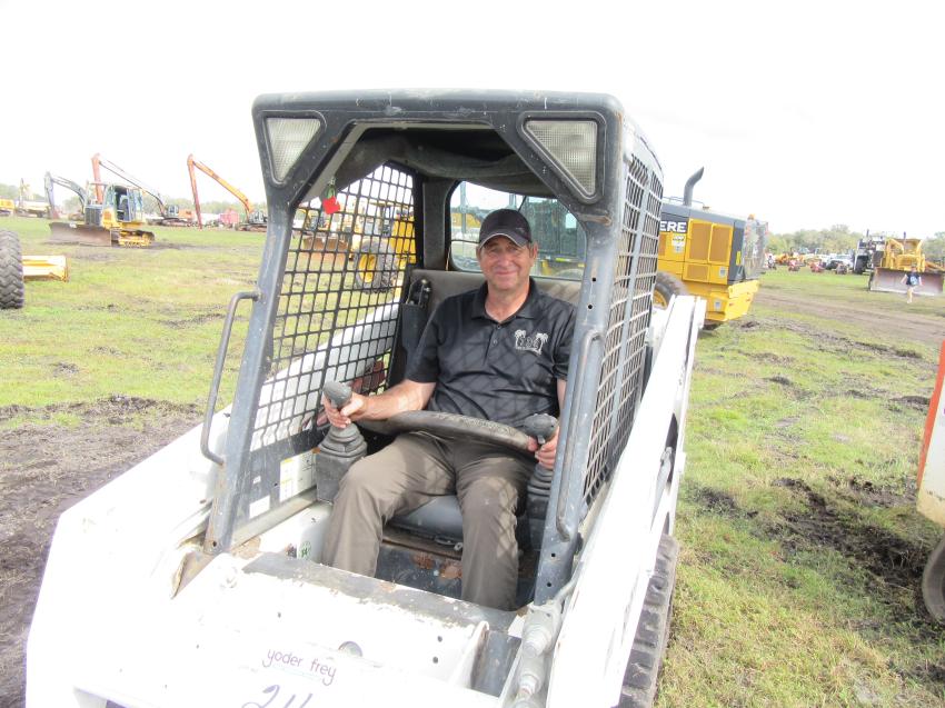 Adrian Diggins of TDS Lawn Maintenance, based in Apopka, Fla., tries out a Bobcat T110  skid steer at the Yoder & Frey auction.
