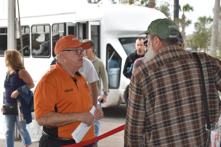 Fred Vilsmeier, auctioneer of Ritchie Bros,. plays a dual roll pointing attendees in the right direction as busloads of bidders arrive ready to make their purchases.