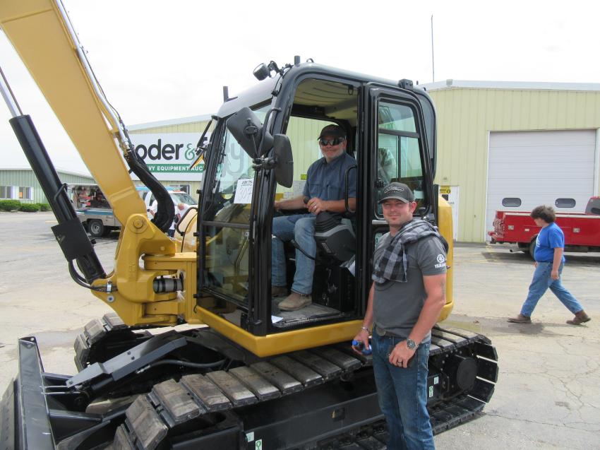 Shane Helms (L) and Eric Barger II of Helms and Sons Excavating try out a Cat 308E2 CR mini-excavator before bidding begins in North Baltimore, Ohio.
