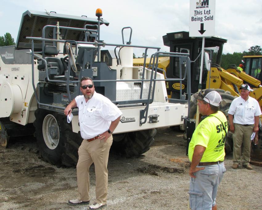 Jeff Martin Auctioneers’ Juston Stelzer (L) calls out another bid from the crowd for a nice late-model Wirtgen WR2000 XL soil stabilizer. 
