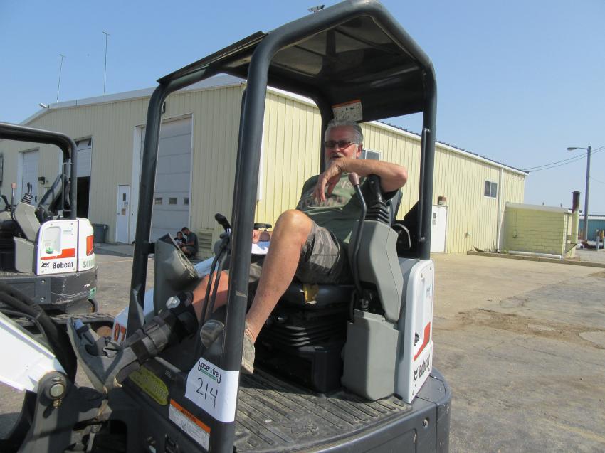 Rico Moore of Michigan Ohio Equipment considers a bid on this Bobcat E35 mini-excavator at the auction.
