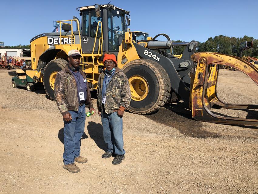 Gary Dorsey (L) and Gordon Moore, both of Dorsey Construction, Augusta, Ga., planned to bid on this John Deere 825K wheel loader equipped with logging attachment. 
