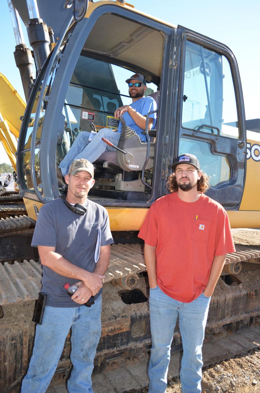 (L-R): Ray McKelvin, Parker Bourque (in cab) and Hayden Rupert, all of Southern Lawn Care & Excavation, Saucier, Miss., gave this Deere a solid inspection. (CEG photo)