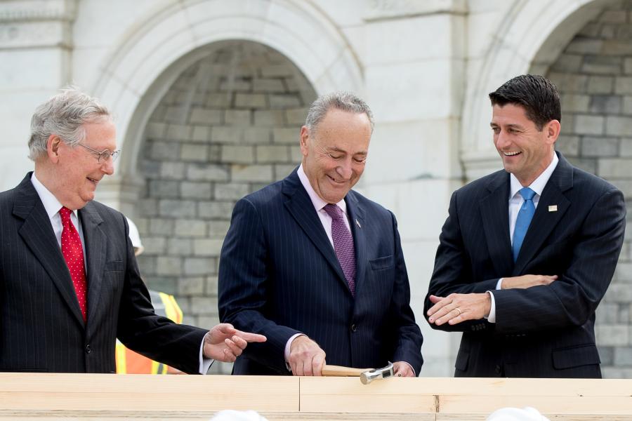 AP Photo/Andrew Harnik). House Speaker Paul Ryan of Wis., right, and Senate Majority Leader Mitch McConnell of Ky., left, laugh at Sen. Charles Schumer, D-N.Y., center, bends his nail during a ceremony to drive in the first nails to signifying the  start of construction on the presidential inauguration platform,