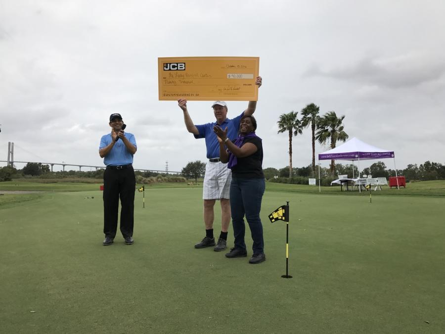 L-R): Arjun Mirdha, JCB North America president and CEO, and Tony Whitehurst, general manager of JCB Finance, present Tammy Mixon, executive director of Wesley Community Centers, with a check for $90,000.