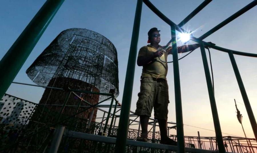 A Sri Lankan port worker welds steel frames to assemble an enormous, artificial Christmas tree on a popular beachside promenade in Colombo, Sri Lanka. Hundreds of Sri Lanka’s port workers and volunteers are struggling to put up the towering Christmas tree in time for the holidays. The majority-Buddhist nation is aiming to beat the world record for the tallest, artificial Christmas tree as a show of multicultural respect.