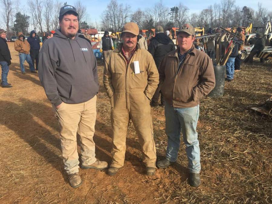 (L-R): Kory Strader of KBS Earthworks in Julian, N.C., and Frank and Nicholas Strader, both of Strader Farms in Julian, N.C., look at the backhoe loaders.