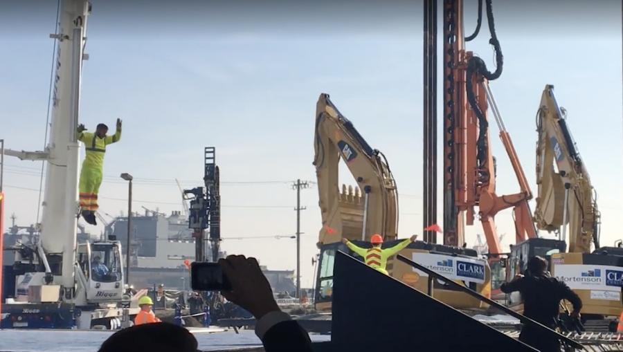 Dancers bust a move as a synchronized performance is put on by 3 excavators.