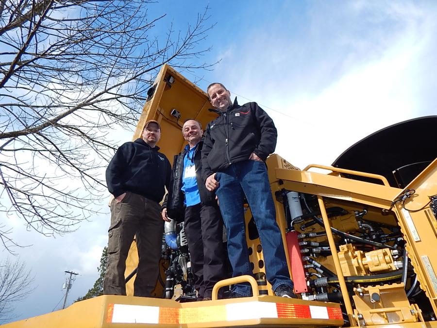 Checking out the specs of this Tigercat are (L-R) Frank Chandler, owner and CEO of C&C Logging, Kelso, Wash.; Ken Grein, design engineer who helped design the Tigercat; and Tim Paul, C&C equipment operator.