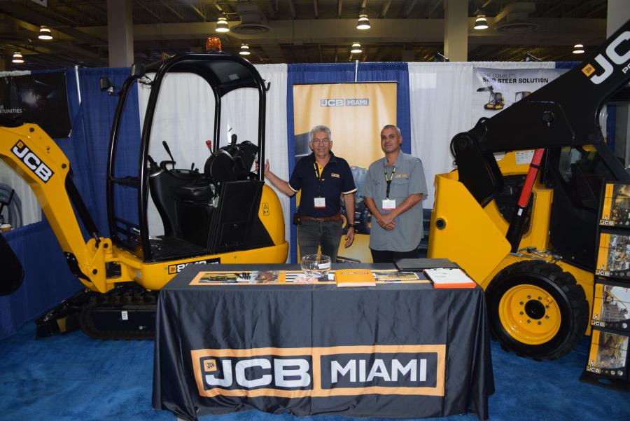 Elio Leon (L) and Kenneth Lemus, both of JCB Miami, discuss the JCB 8018 CTS mini-excavator and the  JCB 190 skid steer.