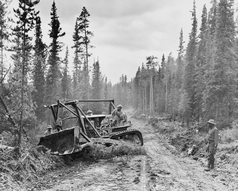 Crews use a Caterpillar tractor with grader to widen the roadway in 1942 during construction of the Alcan.
(Library of Congress photo)