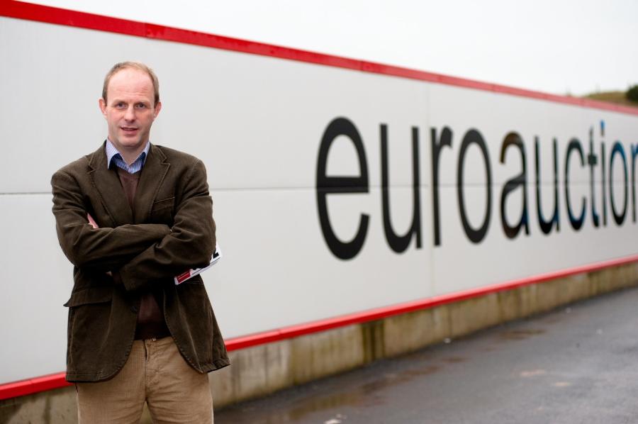 Jonnie Keys in front of Euro Auctions Banner.