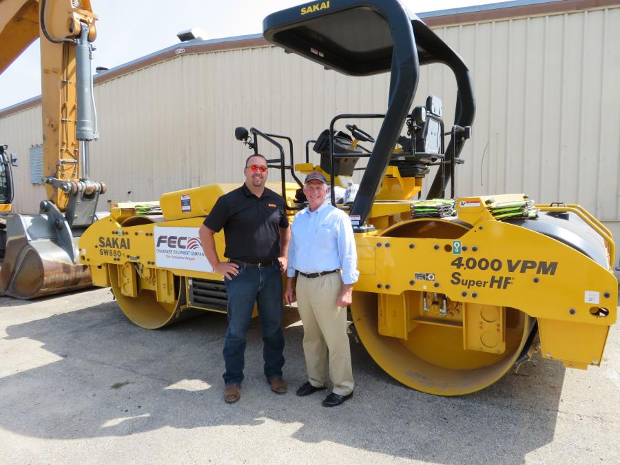 Brett Rymer (L), Sakai America Inc., stands with Andy Bazan, vice president of Finkbiner Equipment Company, in front of the Sakai SW880-1 roller.