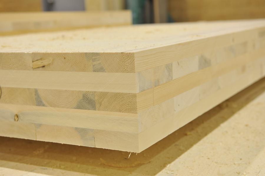 CLT is created by pressing multiple sheets of lumber together with an adhesive and a hydraulic press.