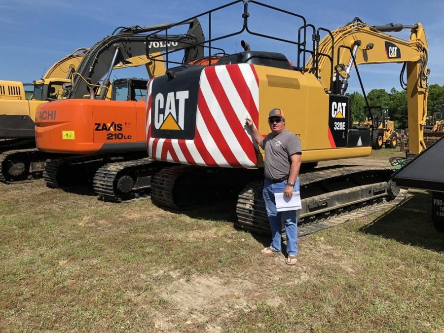 Wayne Smith of Wayne’s Backhoe Service, Shallotte, N.C., takes a closer look at a Cat 320E L excavator.