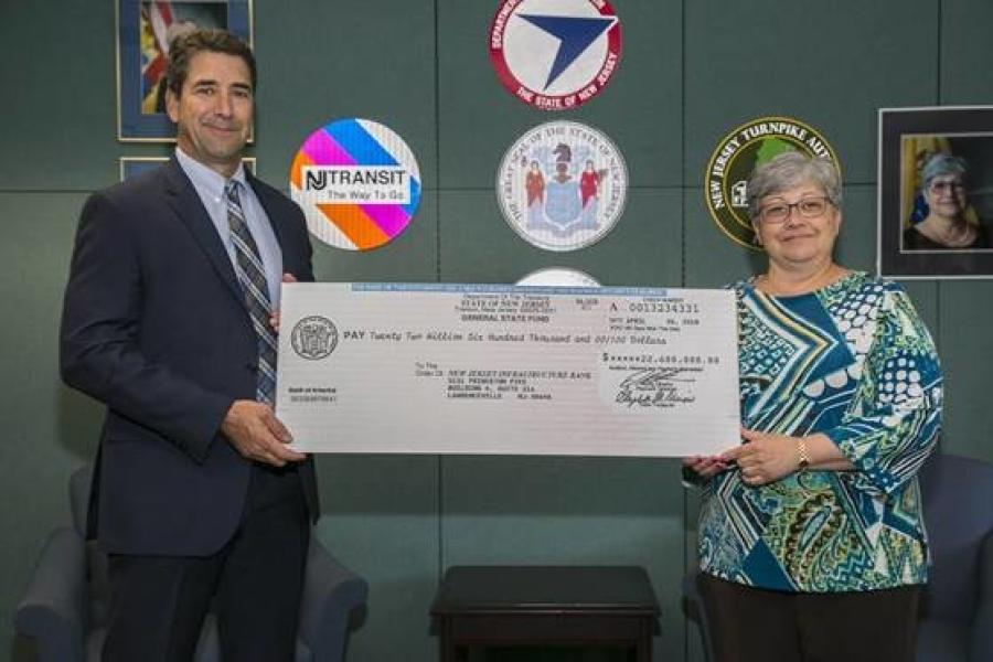 NJDOT Commissioner Diane Gutierrez-Scaccetti presents the I-Bank Vice-Chairman, Robert Briant Jr. with a $22.6 million check from the State Local Aid Infrastructure Fund, marking the launch of the New Jersey Transportation Bank.