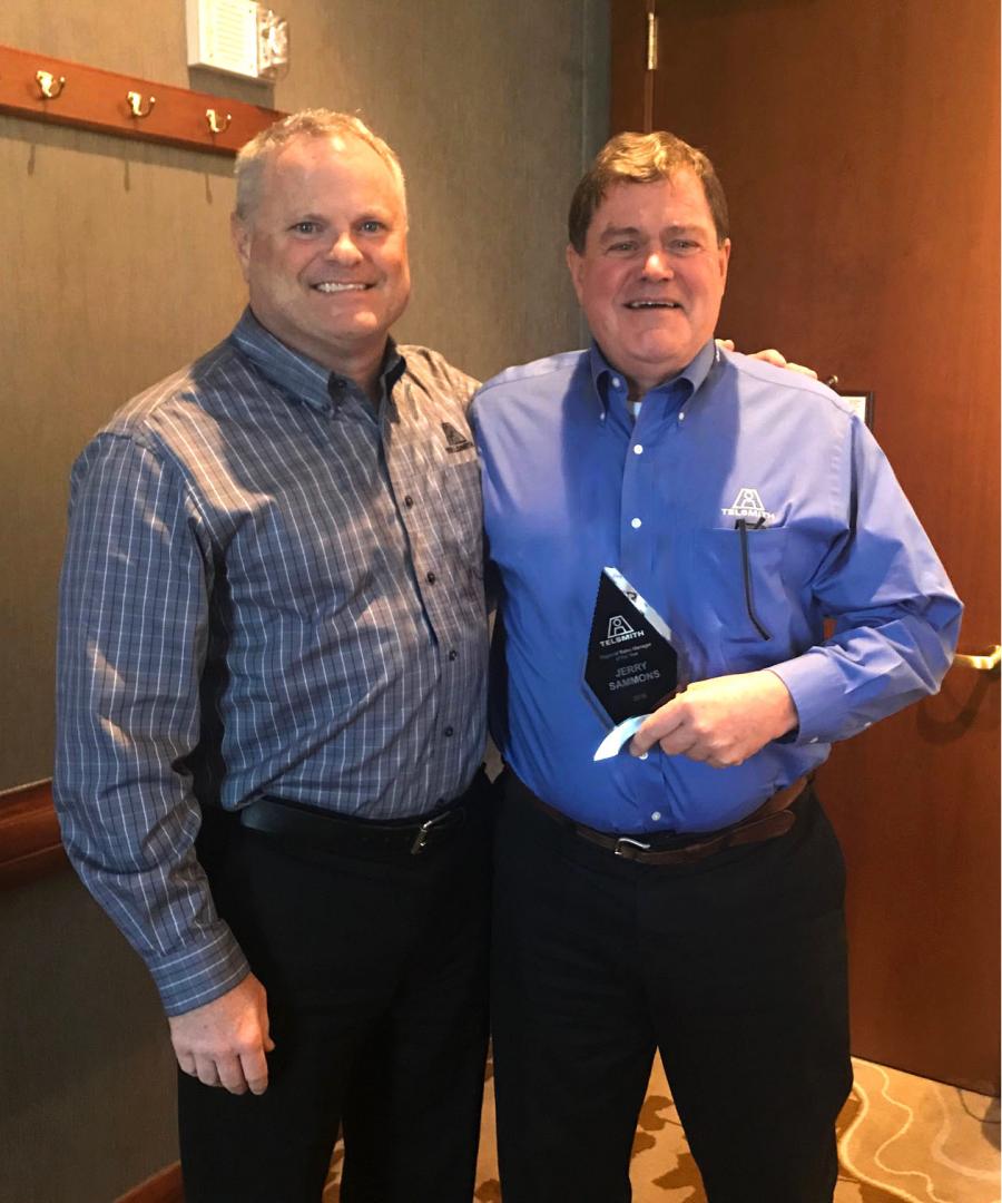 Jeff Gray (L), vice president of sales and marketing of Telsmith Inc., presents Jerry Sammons, regional sales manager, with the company’s 2018 salesperson of the year award.
