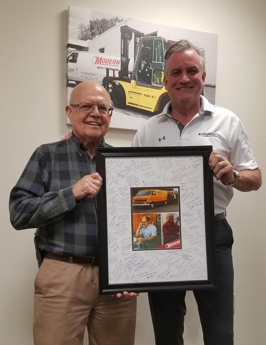 Modern President and CEO Paul Farrell presents Joe Dutko with framed photographs and retirement wishes signed by modern owners.