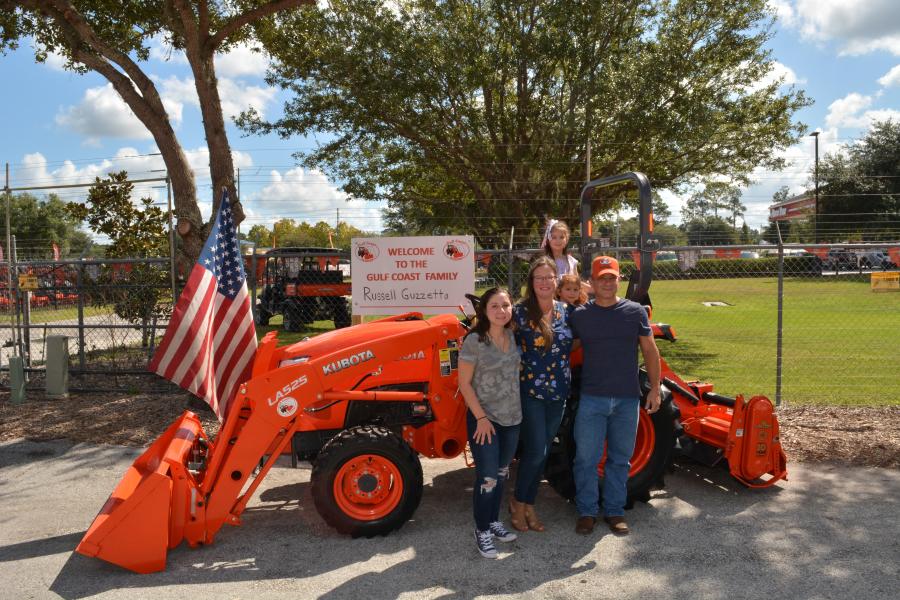 Marine Corps veteran Russell Guzzetta, owner of Country Song Farm in Lithia, Fla., and his family stands in front of the Kubota L Series compact tractor he was awarded through Kubota’s Geared to Give program.