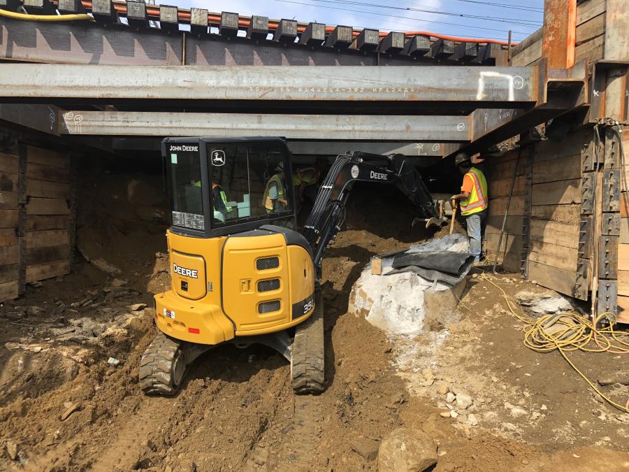 Crews tunnel under the five live tracks to construct abutment #1.