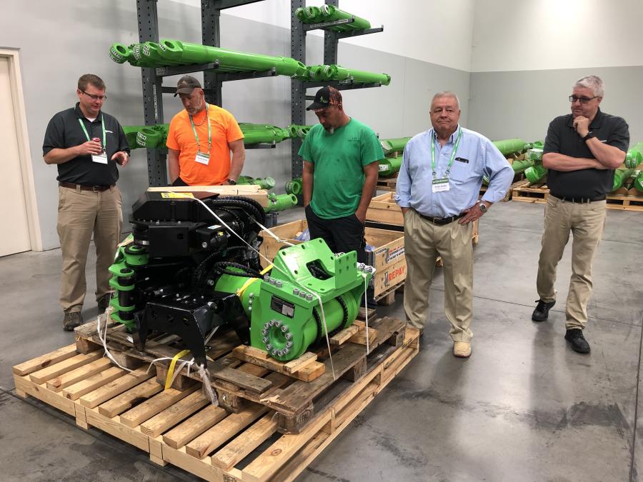 Around the Sennebogen 718 grapple saw attachment (L-R) are Greg Roberts of Sennebogen; Jeremy Lacey and Jason Sykes, both of L&L Tree Service in Jacksonville, N.C.; Terry Jones of Sun Machinery Company in Lexington, S.C.; and Jim Westlake of Sennebogen.
