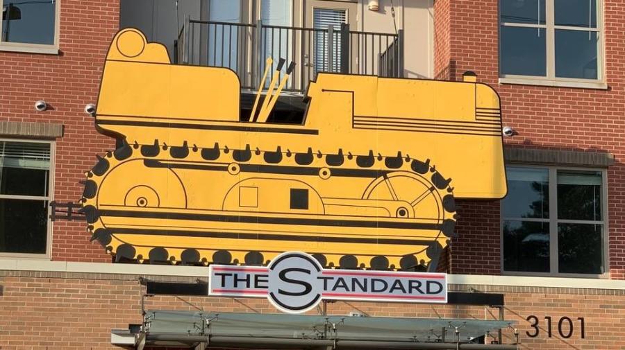 The old tractor sign from the former N.C. Equipment Co. building has a new home on The Standard student apartment building on Hillsborough Street in Raleigh. (Richard Stradling rstradling@newsobserver.com photo)