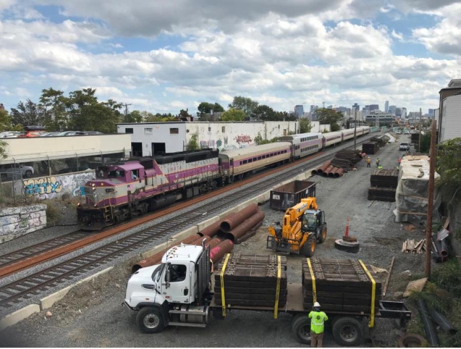 The Green Line Extension under construction next to a Lowell Line commuter rail train, seen from the Cross Street overpass in East Somerville on Oct. 1, 2020. (Mass.Streetsblog.org photo)