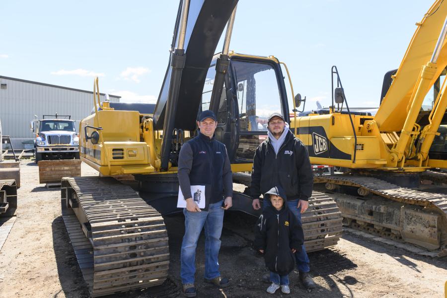 Steve Pchelka (L) of ASP Construction in West Springfield, Mass., and Dan Mikhaylichenko and son, William, of DVM Electric in Holyoke, Mass., stand in front of a 2000 John Deere 200LC hydraulic excavator.