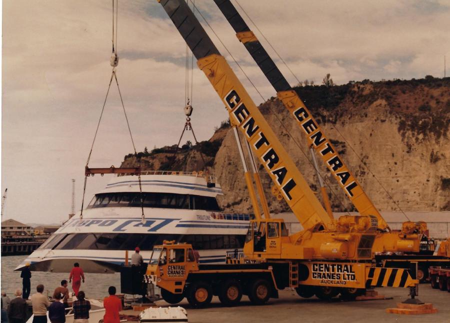 Two cranes, one a 100 ton P & H, owned by Central Cranes Ltd. of Auckland, New Zealand, lift the hull of a Lake Taupo tour boat. 
(Graham Brent Paper, HCEA Archives photo)