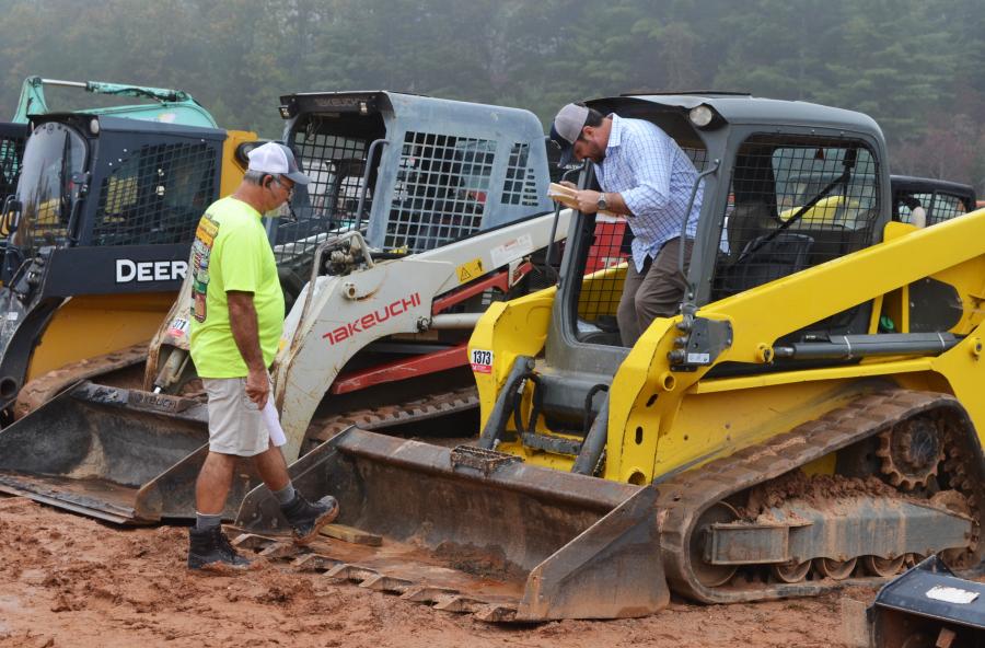 Grady Smith (L) of Martin Construction & Grading, Toccoa, Ga., and Roy Shore, a North Carolina contractor, tag-team machine inspections on some compact track loaders of common interest.    
