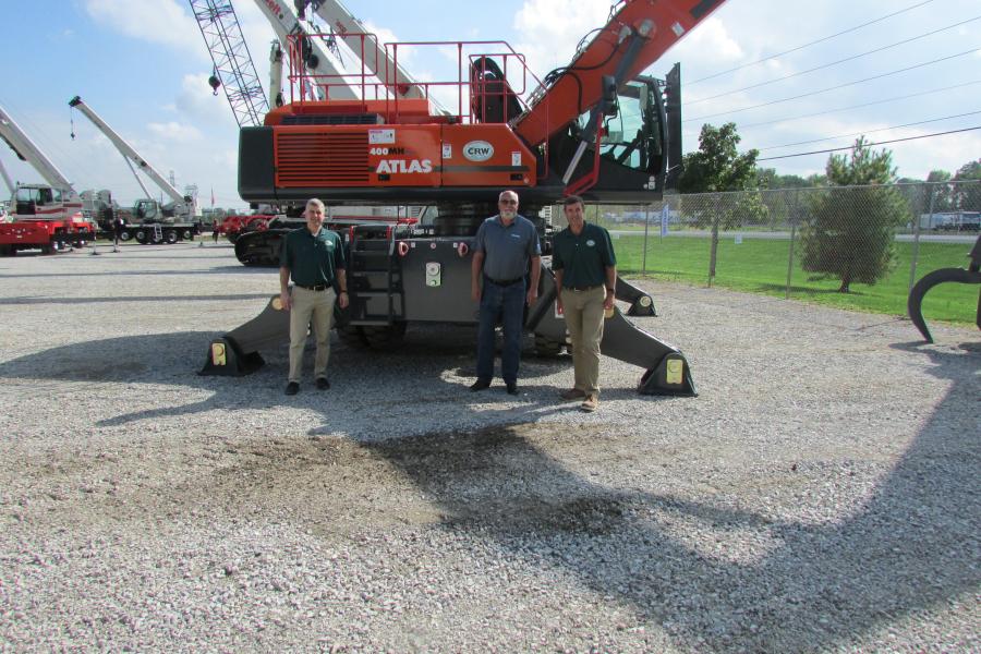 (L-R): Andre Parent, vice president/earthmoving division, Woods CRW; Tom Hickson, general manager, SMH Group; and Chris Palmer, president of Woods CRW, proudly stand in front of a new Atlas material handler. Woods CRW recently brought on the line and showcased it during the open house for the first time.