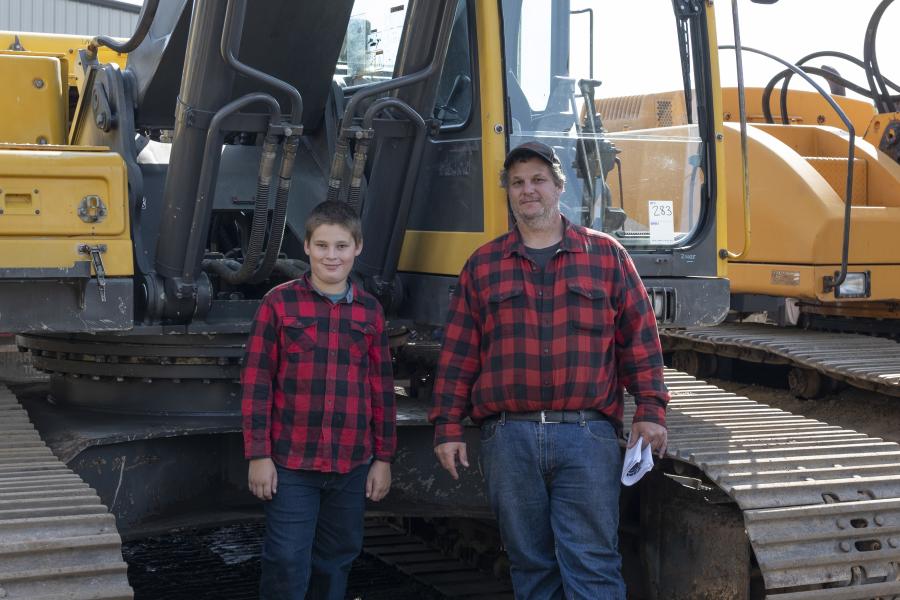 Father and son, Ron (R) and Jake Comarella of Union, Conn., check out a 2004 Volvo EC290BLC hydraulic excavator.