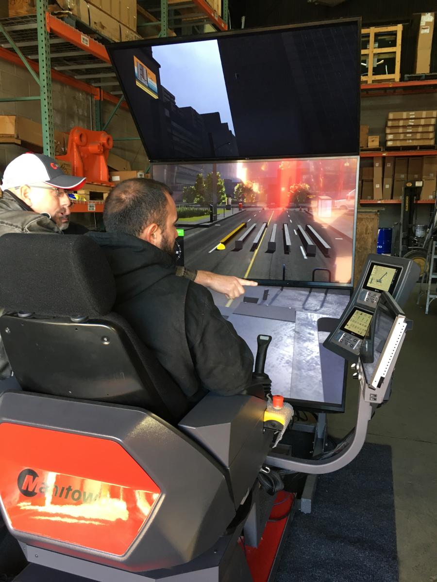 A Hoffman Equipment open house guest takes a spin (and a lift) in the Manitowoc crane simulator.