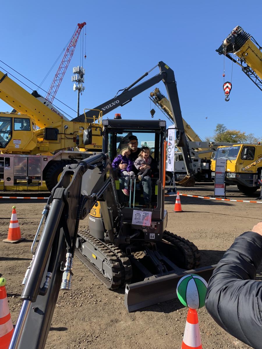Caleb Janho, representing Cedar Hill Landscaping, Somerset, N.J., took his daughters Raelynn (L) and Felicity for a ride in the Volvo ECR25 electric compact excavator.