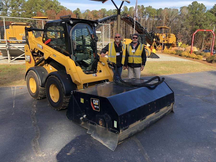 Looking over a Cat 243D3 skid steer with a Cat BU118 broom attachment are Andy Brown (L) of Fred Smith Company in Raleigh, N.C., and Bryant Balentine of Gregory Poole.