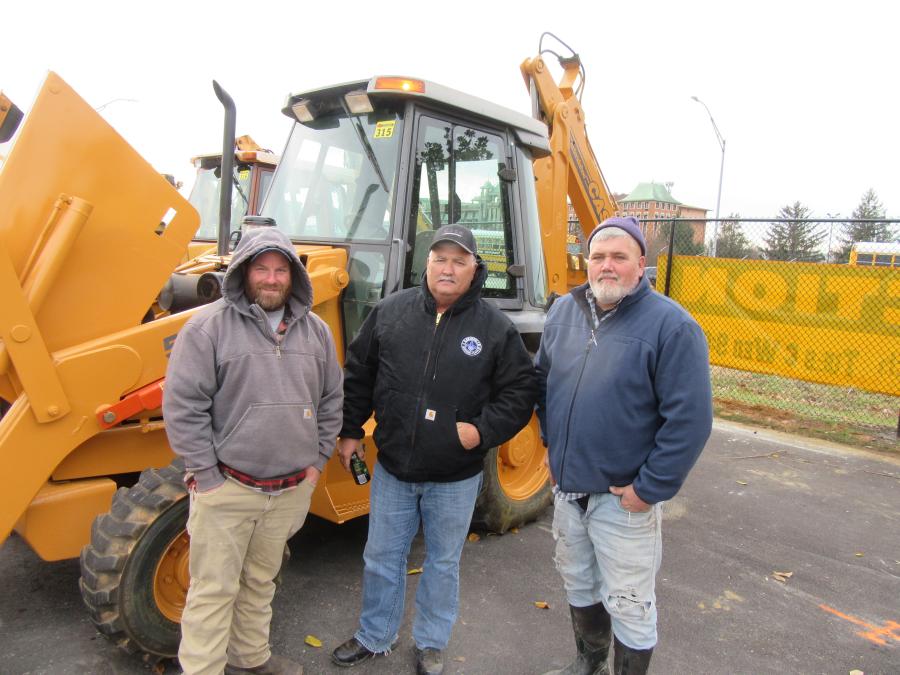 (L-R): Mickey England, along with Randall and Harold Smith, consider a bid on this Case 580L backhoe.
